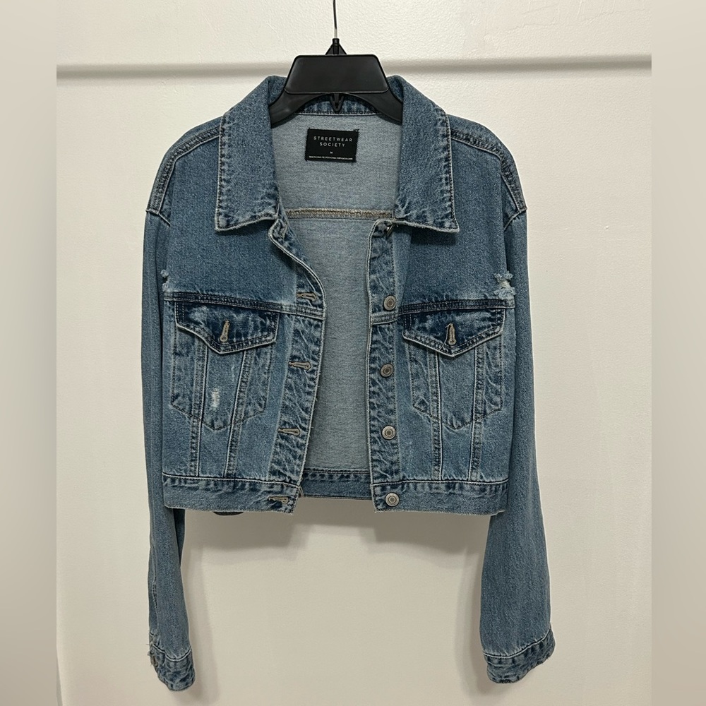 Distressed jean jacket. Cropped length